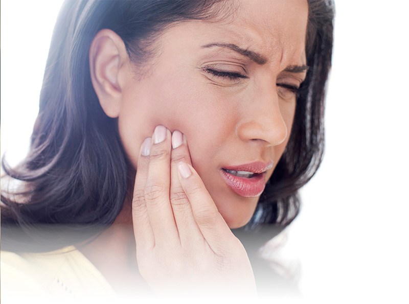 A woman holding her jaw in pain