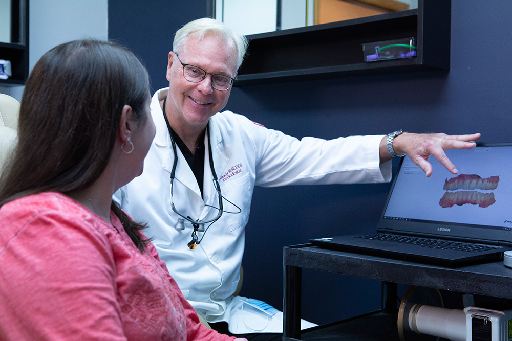 Dr. Nolf with a patient looking at a 3D model of the teeth and gums